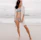 woman in white long sleeve shirt and white panty standing on beach during daytime